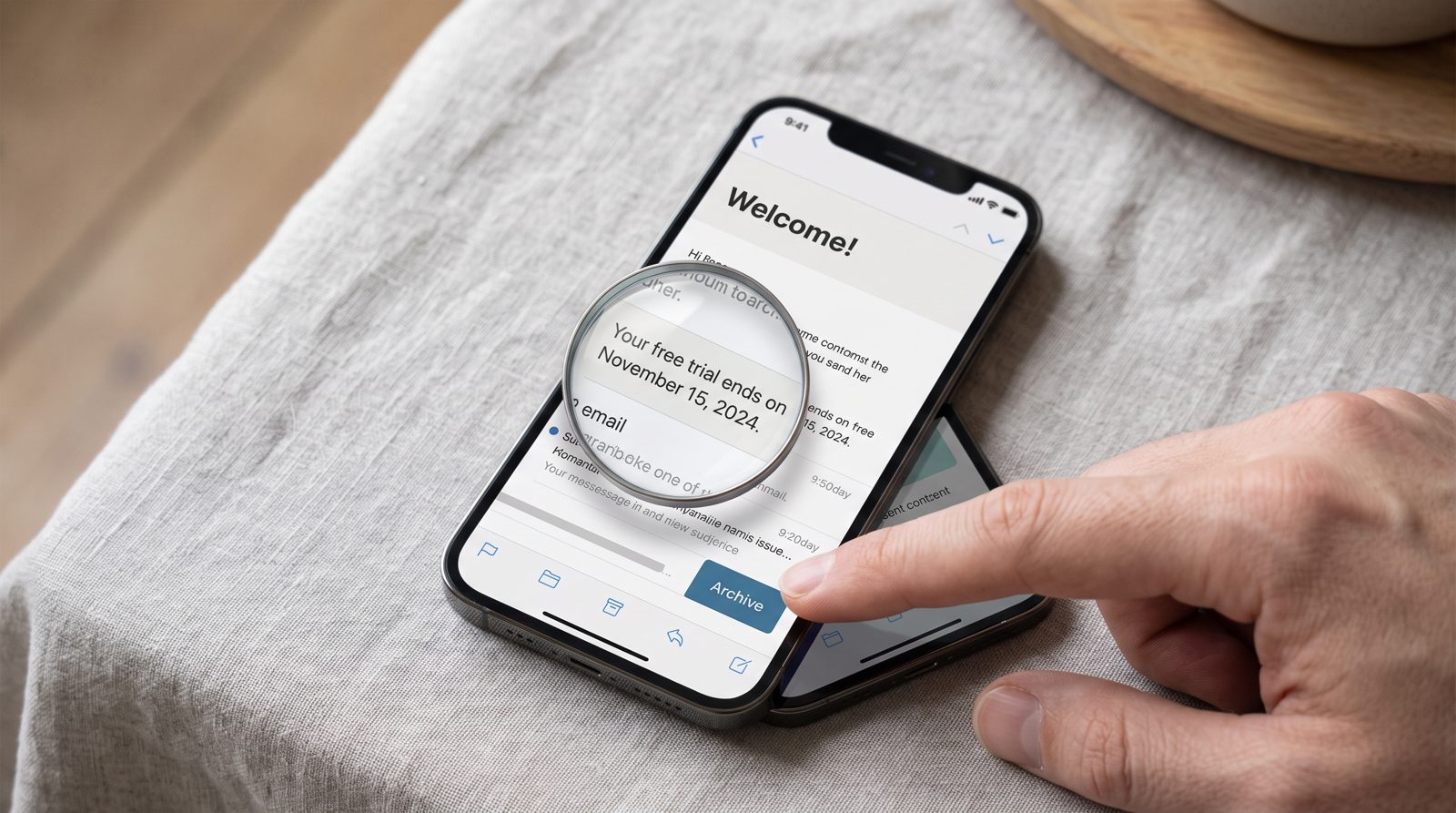 Nagyító egy telefon felett, amely a „Your free trial ends on November 15" sorát nagyítja meg, amint egy ujj az Archive felé ér